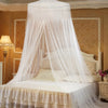A large sheer white mosquito net draped over a bed, providing protection for the bedding and home area.