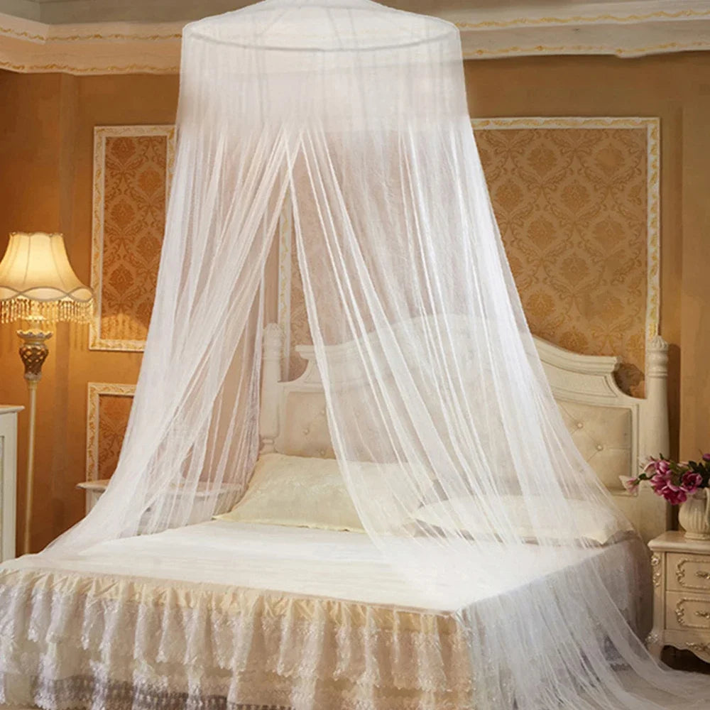 A large sheer white mosquito net draped over a bed, providing protection for the bedding and home area.