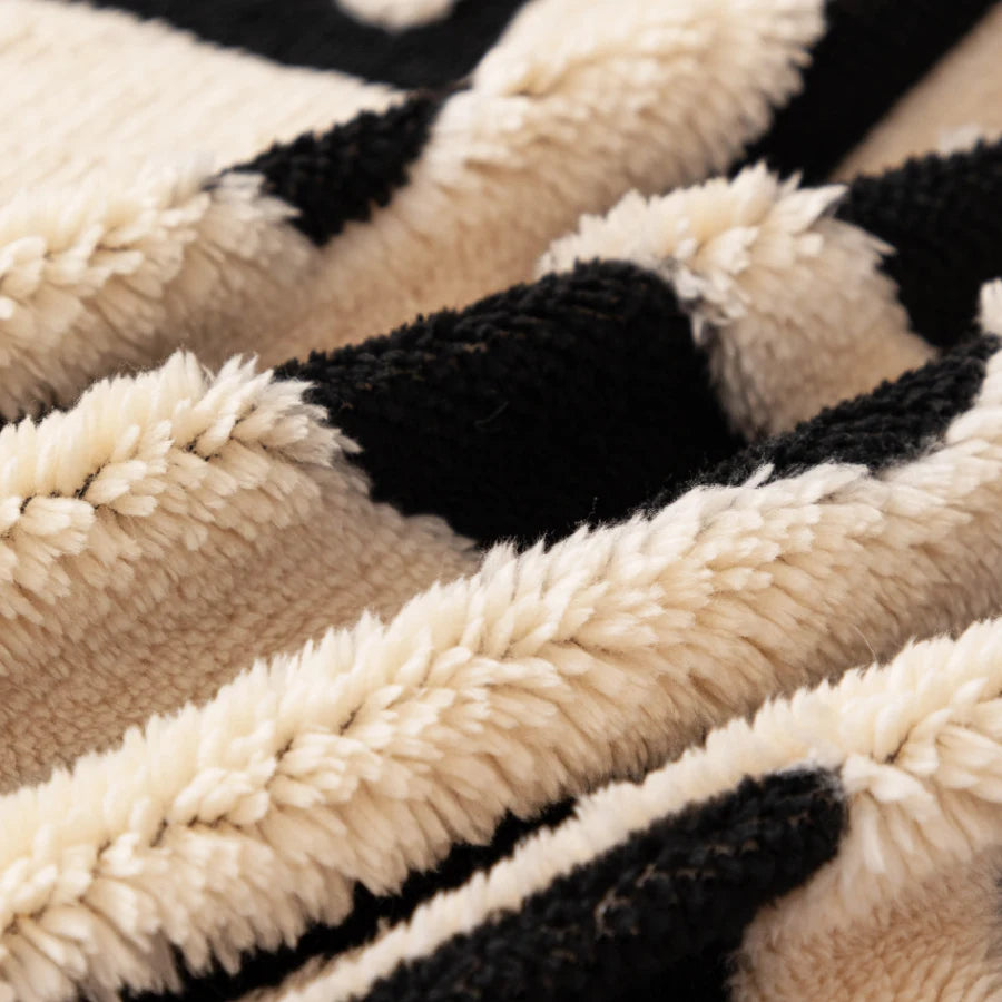 Close-up of a vintage bohemian knit sofa protector featuring black and cream striped texture.