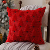 A red knitted throw pillow with a textured pattern resembling Christmas trees, resting on a gray blanket.