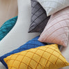 A collection of decorative pillow covers in various shades including teal, gray, pink, and yellow.