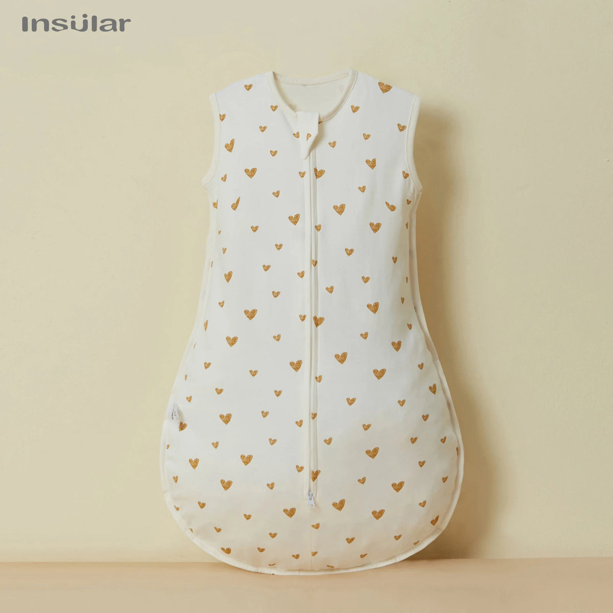 A white cotton sleep sack for baby or toddler with small gold heart embroidery.