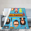 A blue throw blanket featuring cartoon characters from Bob's Burgers, including Tina Belcher and Linda Belcher.