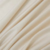 Soft beige luxury bamboo flat sheets draped in flowing fabric