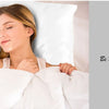 A woman rests her head on a white satin pillow, looking peaceful and beautiful.