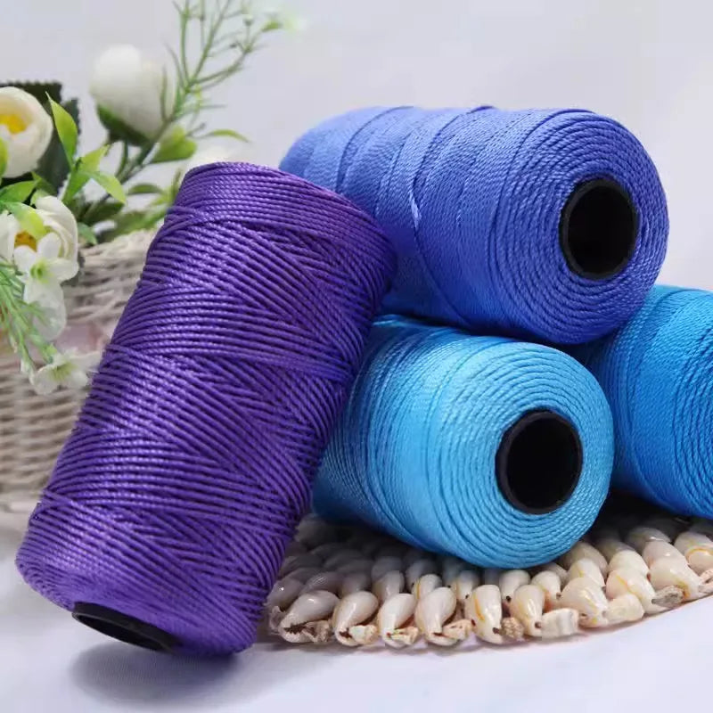 Rolls of colorful crochet ice rope in purple, blue, and cyan stacked on a surface.