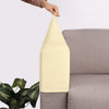 A beige velvet sofa armrest cover being held by a hand, shown next to a gray sofa.