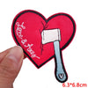 Red heart shaped embroidered patch featuring a white letter iron and a small black thread detail.