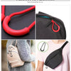 Red and black U-shape zipper pull straps shown in close-up against a dark background and attached to a gray fabric bag.