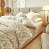 A cozy fleece blanket in beige is draped over a bed with white pillows and modern decor.