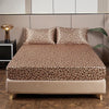 A bed featuring a leopard print satin sheet set on a modern bed with neutral tones.