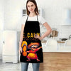 A woman wearing a black apron with a colorful Mexican-inspired character design standing in a kitchen.