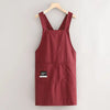 A maroon water-resistant kitchen apron hanging on a wooden hanger.