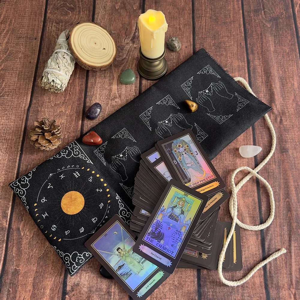 A black fabric pouch filled with tarot cards and accessories rests on a wooden surface.