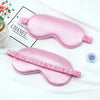 Pink silk sleep mask with ruffled edge displayed on a white background.