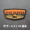 An embroidered patch with the text ALWAYS BE READY FIVE ELEVEN and a silhouette of a vehicle against a forest background.