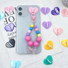 A collection of pink and purple metal heart phone charms and connectors displayed on a white background.