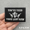 Black embroidered patch with white text YOU'YE YEED YOUR LAST HAW featuring cowboy silhouettes