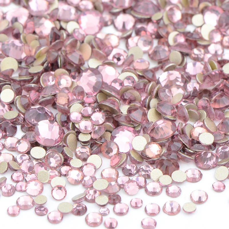 A pile of pink and champagne clear glass rhinestones for DIY crafts