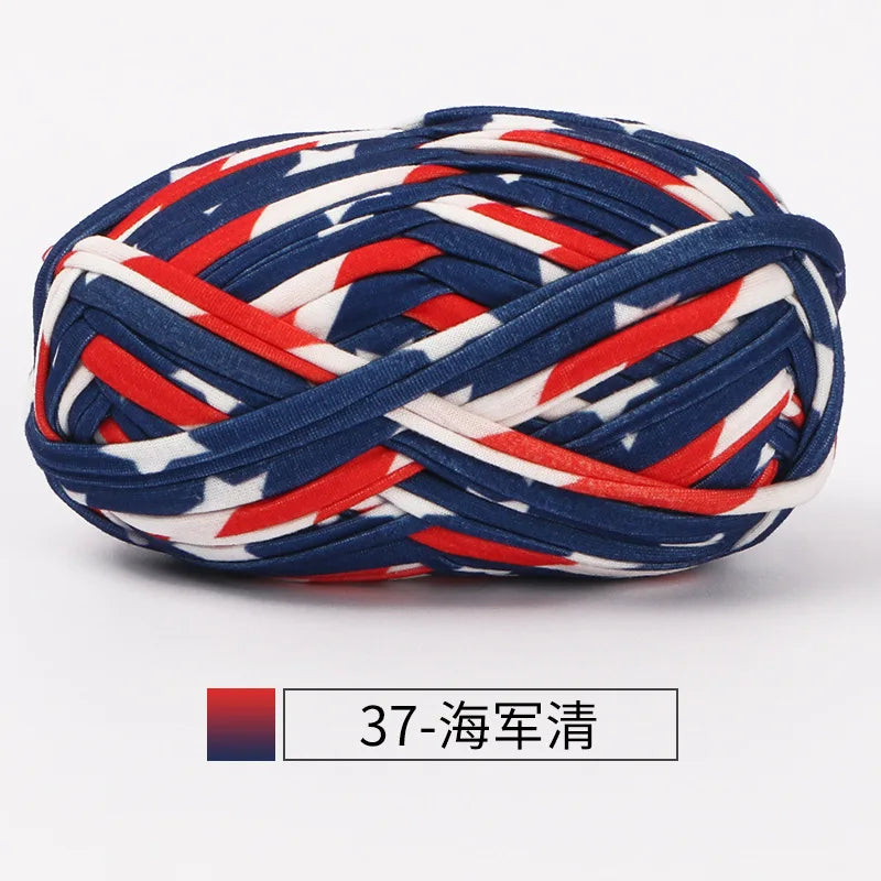 A ball of hand-dyed fabric strip yarn featuring a patriotic design with red, white, and blue stripes and stars.