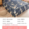 A dark blue printed bed skirt with a ruffled hem and floral pattern displayed on a bed.