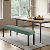 A modern, dark wood dining table is shown with a light green stretch jacquard bench cover and a gray rug in a bright room.