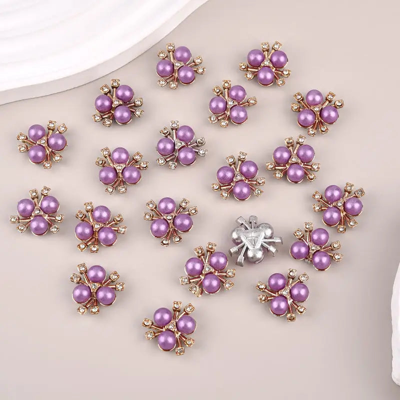 A set of flower-shaped resin buttons adorned with purple and silver rhinestones.