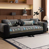 A dark gray sofa with a Christmas deer pattern mat cover and decorative pillows in a modern living room.