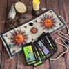 A tarot card storage pouch featuring a mystical tree of life design, surrounded by crystals and a pinecone.