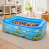 A bright blue inflatable pool filled with colorful balls rests on a cream rug indoors.