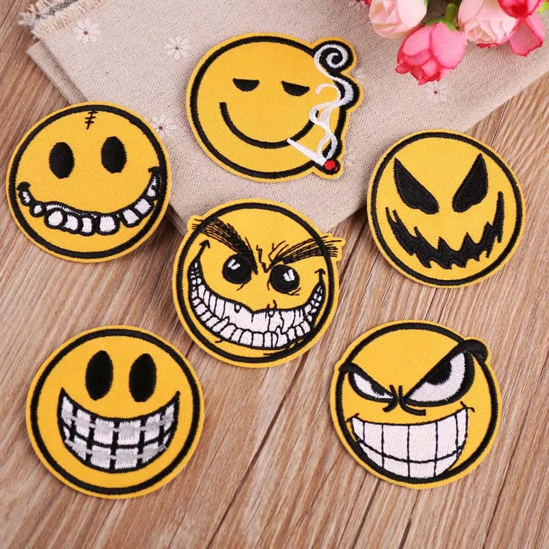 A collection of yellow embroidered patches featuring various funny and scary emoji faces.