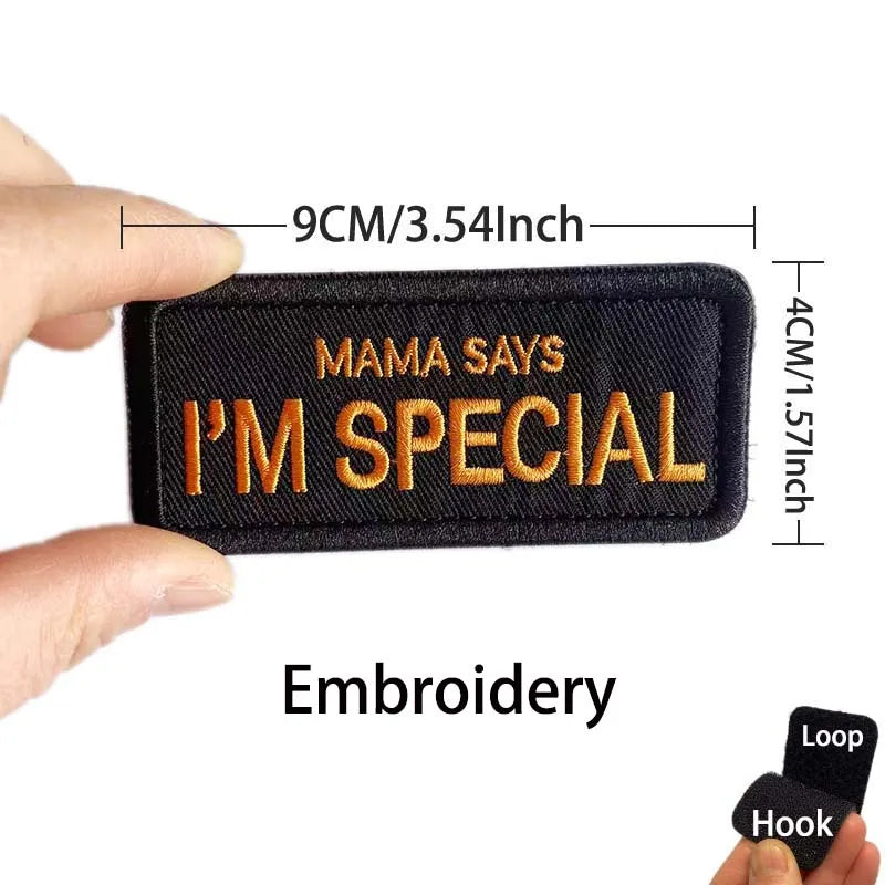 A black embroidered patch with the text Mama Says I'm Special is shown being held by a hand.