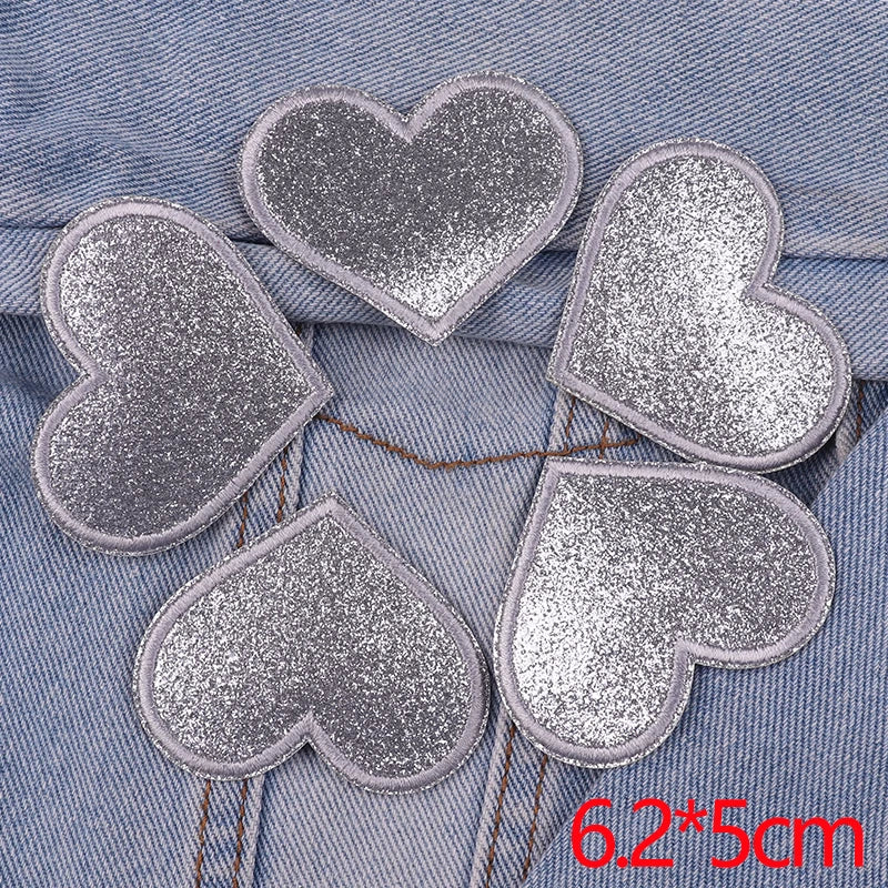 Five glitter iron-on embroidered love heart star patches are displayed on a blue denim fabric.