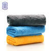 A stack of three coral fleece microfiber cleaning cloths in gray, blue, and yellow.