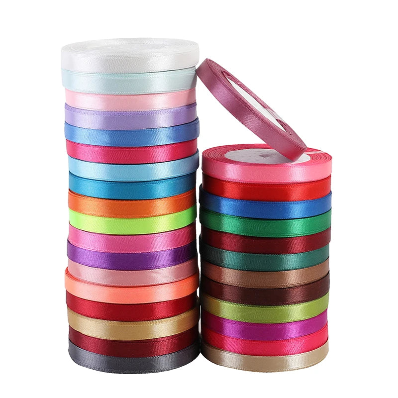 A stack of satin ribbon rolls in various colors, including pink, blue, green, and red.