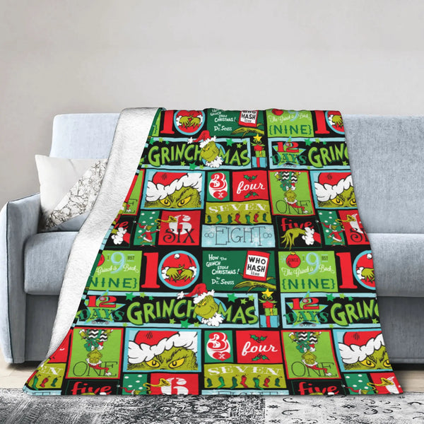 A colorful Christmas themed plaid throw blanket draped over a gray sofa.