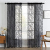 Black sheer floral lace curtain panels hanging over a window.