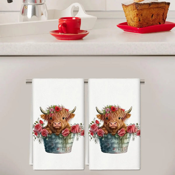 A kitchen towel featuring a watercolor illustration of a pig face surrounded by pink and red flowers in a blue bucket.