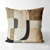 A decorative pillow cover featuring a geometric pattern of beige, brown, and gray tones.