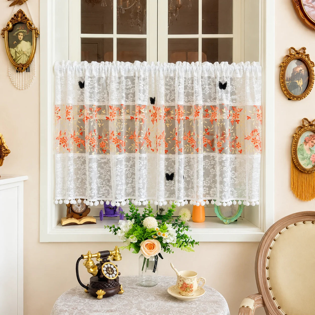 White lace cafe curtain with orange floral embroidery and black butterfly appliqués displayed in a window frame.