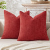A close-up of a textured, deep red chenille pillow cover with a subtle diamond tufting pattern.