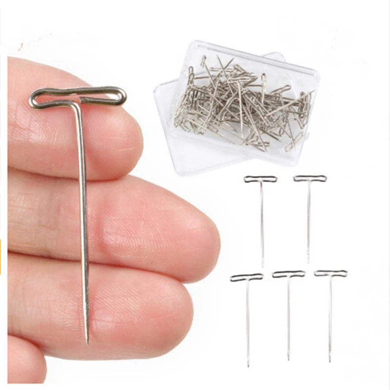 Stainless steel T-pins for wig making and knitting shown in a clear plastic container and loose.