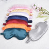 A collection of silk sleep masks in various pastel and jewel tones laid out on a white surface.