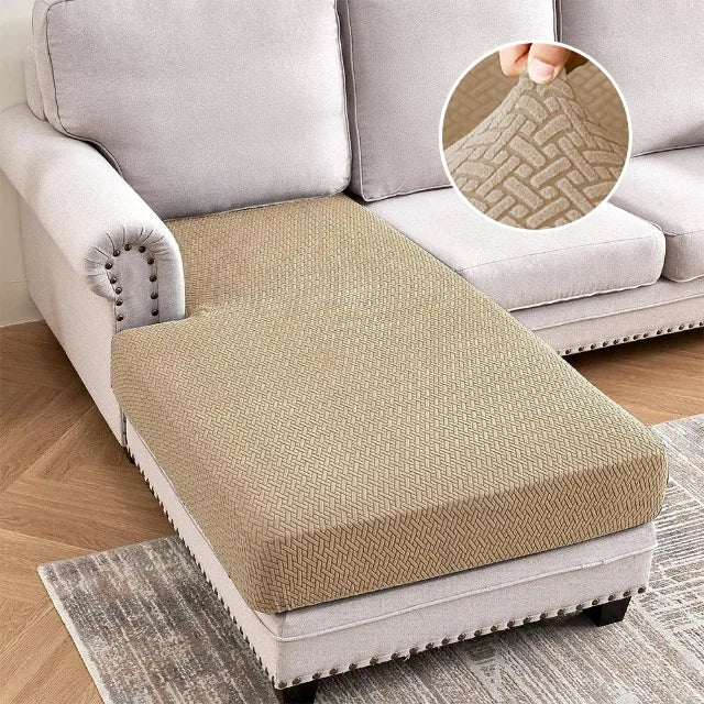 A beige stretch sofa cushion cover placed on a light gray sofa, with a close-up showing the woven texture.