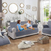 A light blue reversible sofa slipcover is displayed in a living room setting with natural light and decorative elements.