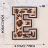 A black leopard print alphabet iron-on patch letter E with dimensions 4.5cm by 6cm and a weight of 1.2g.