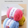 A stack of pink, blue, and yellow soft yarn skeins for hand knitting.
