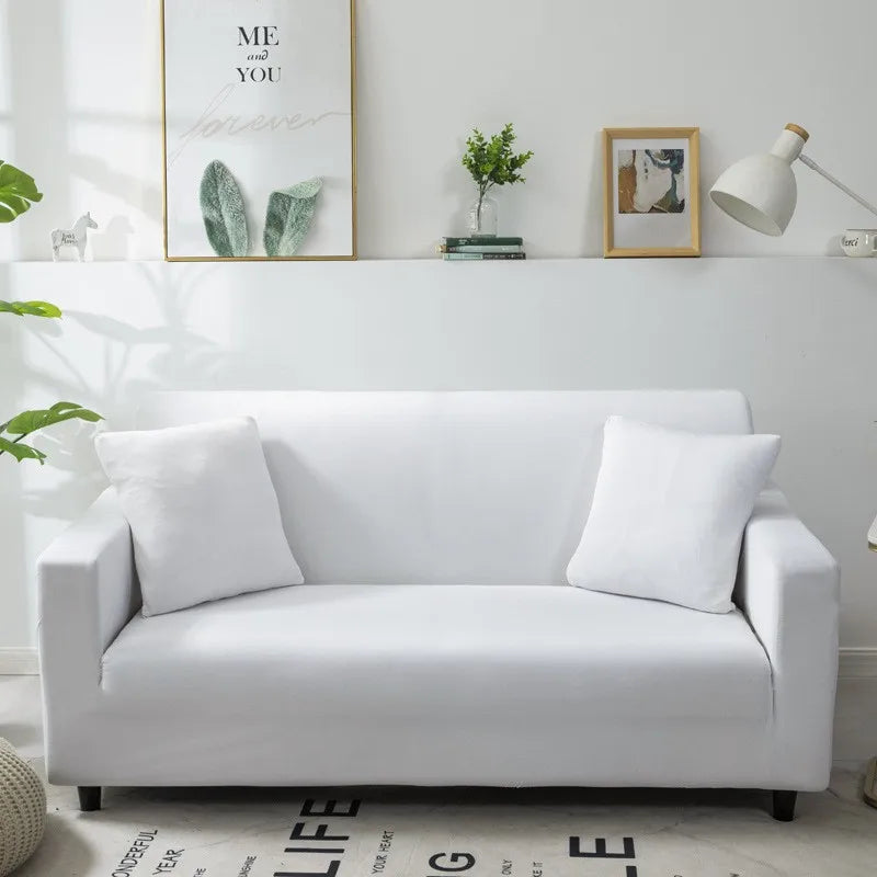 A white elegant faux silk sofa cover displayed on a light gray wall with framed art.