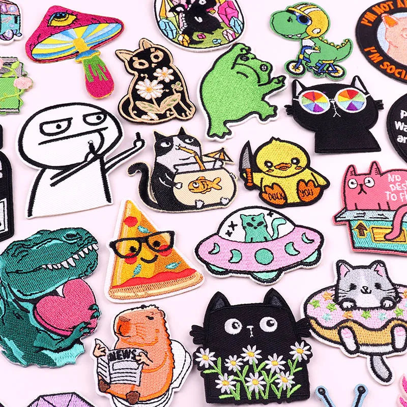 A collection of embroidered iron-on patches featuring various cartoon cats and animals.