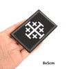 Black embroidered military cross shield hook and loop patch shown being held in a hand.